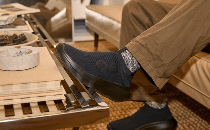 Men's OOmy Zen - Black shoe on model sitting on couch resting foot on coffee table | lifestyle